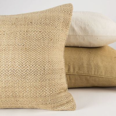 Chevron hand-loomed silk decorative pillow in a natural beige zigzag weave, styled with ivory and gold silk pillows.