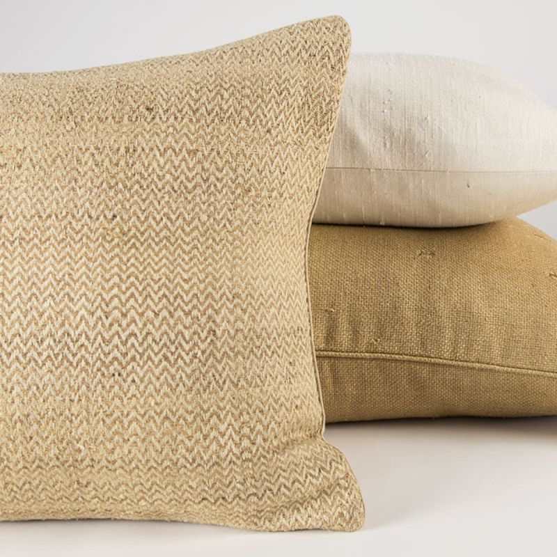 Chevron hand-loomed silk decorative pillow in a natural beige zigzag weave, styled with ivory and gold silk pillows.